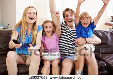 Stock Photo - Family Watching Soccer on TV Celebrating Goal. Fotosearch