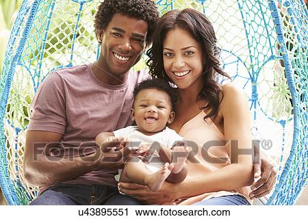 Family With Baby Relaxing On Outdoor Garden Swing Seat View Large Photo Image Stock Image - Family With Baby Relaxing On Outdoor Garden Swing Seat. Fotosearch