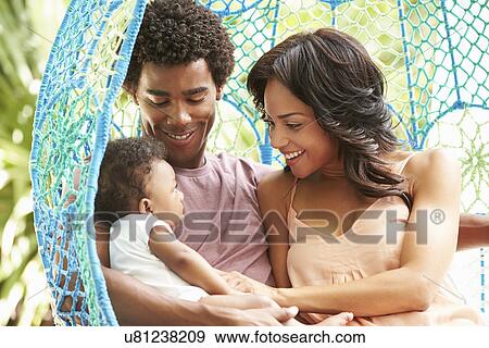 Family With Baby Relaxing On Outdoor Garden Swing Seat View Large Photo Image Stock Photo - Family With Baby Relaxing On Outdoor Garden Swing Seat. Fotosearch