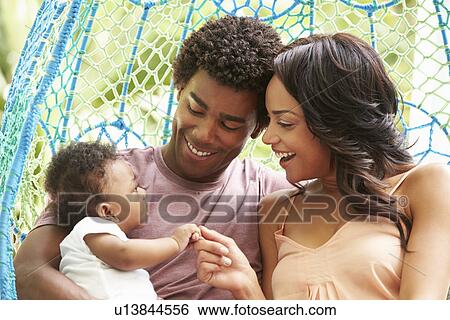 Family With Baby Relaxing On Outdoor Garden Swing Seat View Large Photo Image Stock Photograph - Family With Baby Relaxing On Outdoor Garden Swing Seat. Fotosearch