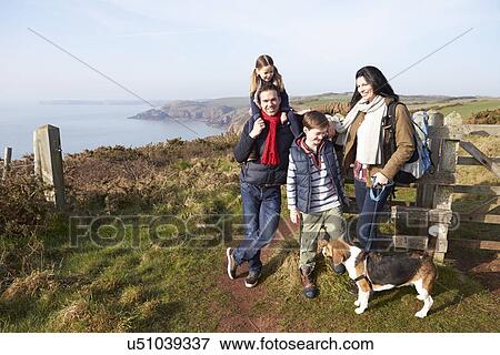 Stock Photo - Family With Dog Walking Along Coastal Path. Fotosearch