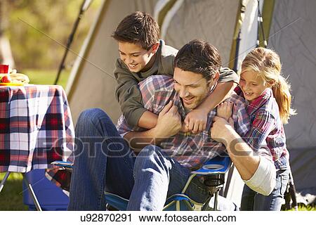 Stock Image - Father And Children Enjoying Camping Holiday In Countryside. Fotosearch