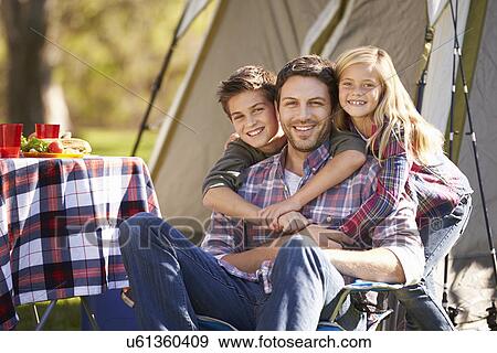 Stock Photo - Father And Children Enjoying Camping Holiday In Countryside. Fotosearch