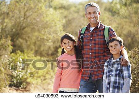 Father And Children Hiking In Countryside Wearing Backpacks View Large Photo Image Stock Image - Father And Children Hiking In Countryside Wearing Backpacks. Fotosearch