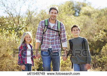 Father And Children Hiking In Countryside Wearing Backpacks View Large Photo Image Stock Photo - Father And Children Hiking In Countryside Wearing Backpacks. Fotosearch