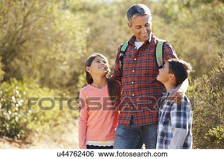 Father And Children Hiking In Countryside Wearing Backpacks View Large Photo Image Stock Photograph - Father And Children Hiking In Countryside Wearing Backpacks. Fotosearch