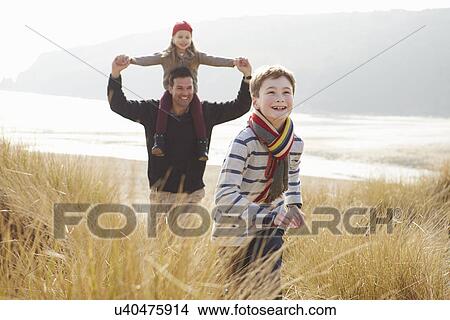Father And Children Walking Through Dunes On Winter Beach View Large Photo Image Picture - Father And Children Walking Through Dunes On Winter Beach. Fotosearch