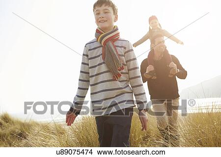 Picture - Father And Children Walking Through Dunes On Winter Beach. Fotosearch