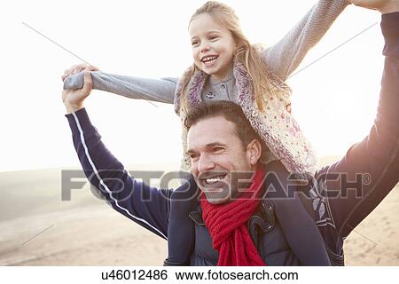 Stock Photograph - Father And Daughter Walking On Winter Beach. Fotosearch