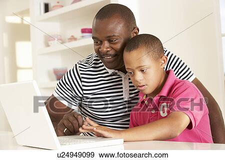 Stock Photo - Father and Downs Syndrome son with laptop. Fotosearch