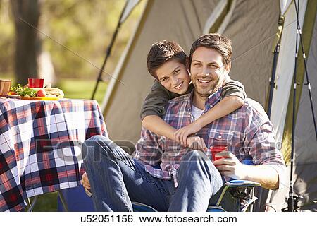 Stock Photograph - Father And Son Enjoying Camping Holiday In Countryside. Fotosearch