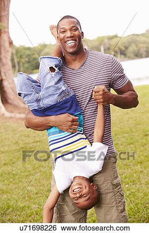 Stock Photograph - Father And Son Having Fun In Garden Together. Fotosearch