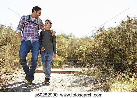 Father And Son Hiking In Countryside Wearing Backpacks View Large Photo Image Stock Image - Father And Son Hiking In Countryside Wearing Backpacks. Fotosearch