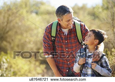 Father And Son Hiking In Countryside Wearing Backpacks View Large Photo Image Stock Image - Father And Son Hiking In Countryside Wearing Backpacks. Fotosearch