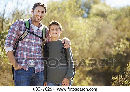 Father And Son Hiking In Countryside Wearing Backpacks View Large Photo Image Stock Photo - Father And Son Hiking In Countryside Wearing Backpacks. Fotosearch