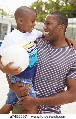 Picture - Father And Son Playing Game Of Volleyball In Garden . Fotosearch