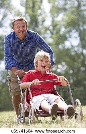 Father and son playing with go-kart View Large Photo Image Picture - Father and son playing with go-kart. Fotosearch