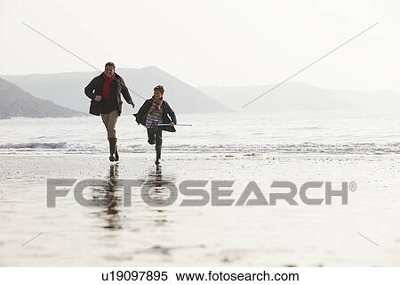 Stock Photography - Father And Son Running On Winter Beach With Fishing Net. Fotosearch