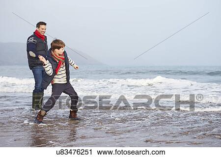 Father And Son Walking On Winter Beach And Throwing Stones View Large Photo Image Stock Image - Father And Son Walking On Winter Beach And Throwing Stones. Fotosearch
