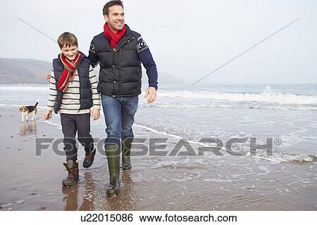 Stock Photograph - Father And Son Walking On Winter Beach. Fotosearch