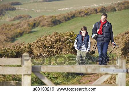Stock Photo - Father And Son With Dog Walking Along Coastal Path. Fotosearch