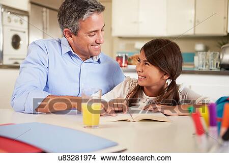 Father Helping Daughter With Reading Homework At Table View Large Photo Image Picture - Father Helping Daughter With Reading Homework At Table. Fotosearch