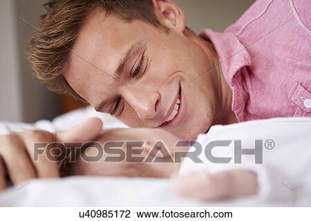 Father Playing With Baby Girl As They Lie In Bed Together View Large Photo Image Stock Image - Father Playing With Baby Girl As They Lie In Bed Together. Fotosearch
