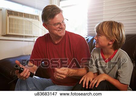 Stock Photo - Father Showing Son How To Use Gun At Home. Fotosearch