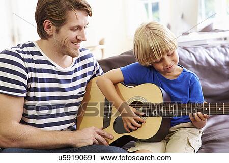 Stock Image - Father Teaching Son To Play Guitar. Fotosearch