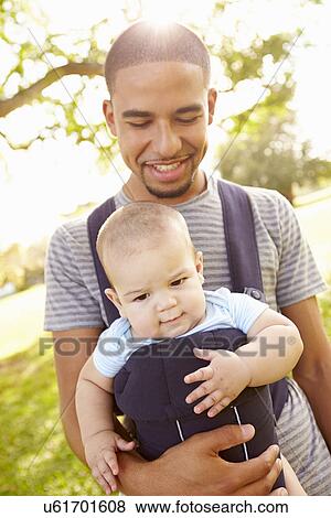 Father With Son In Baby Carrier Walking Through Park View Large Photo Image Stock Photo - Father With Son In Baby Carrier Walking Through Park. Fotosearch