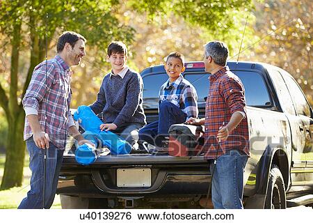 Fathers With Sons Unpacking Truck On Camping Holiday View Large Photo Image Stock Photograph - Fathers With Sons Unpacking Truck On Camping Holiday. Fotosearch