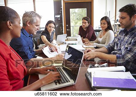 Stock Image - Female Architect Working At Desk On Computer. Fotosearch