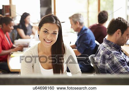 Female Architect Working At Desk With Meeting In Background View Large Photo Image Stock Image - Female Architect Working At Desk With Meeting In Background. Fotosearch