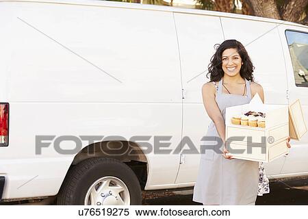 Stock Photography - Female Baker Delivering Cakes Standing In Front Of Van. Fotosearch