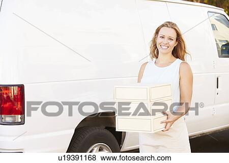 Stock Photo - Female Baker Unloading Cakes From Van. Fotosearch