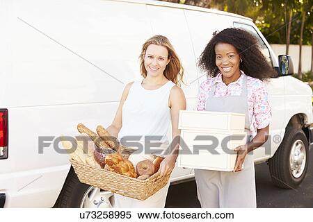 Stock Photography - Female Bakers Unloading Bread And Cakes From Van. Fotosearch