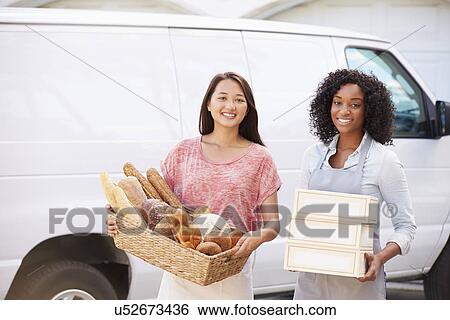 Stock Photograph - Female Bakers With Bread And Cakes Standing In Front Of Van. Fotosearch