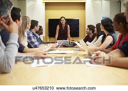Female Boss Addressing Meeting Around Boardroom Table View Large Photo Image Stock Image - Female Boss Addressing Meeting Around Boardroom Table. Fotosearch