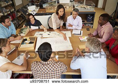 Female Boss Leading Meeting Of Architects Sitting At Table View Large Photo Image Stock Image - Female Boss Leading Meeting Of Architects Sitting At Table. Fotosearch