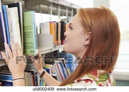 Stock Photo - Female College Student Studying In Library. Fotosearch