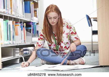 Stock Photo - Female College Student Studying In Library. Fotosearch
