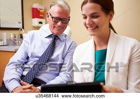 Female Doctor In Consultation With Male Patient View Large Photo Image Picture - Female Doctor In Consultation With Male Patient. Fotosearch