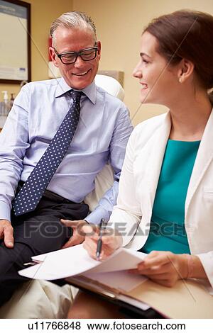 Female Doctor In Consultation With Male Patient View Large Photo Image Stock Photo - Female Doctor In Consultation With Male Patient. Fotosearch