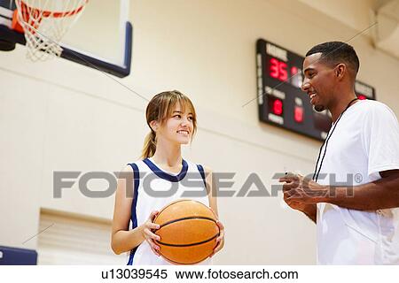 Stock Photography - Female High School Basketball Player Talking With Coach. Fotosearch