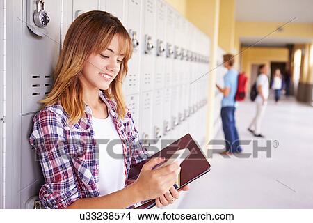 Female High School Student By Lockers Using Mobile Phone View Large Photo Image Picture - Female High School Student By Lockers Using Mobile Phone. Fotosearch