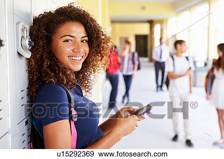 Female High School Student By Lockers Using Mobile Phone View Large Photo Image Stock Photo - Female High School Student By Lockers Using Mobile Phone. Fotosearch
