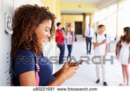 Female High School Student By Lockers Using Mobile Phone View Large Photo Image Stock Photo - Female High School Student By Lockers Using Mobile Phone. Fotosearch