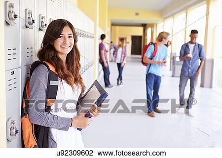 Stock Image - Female High School Student Standing By Lockers. Fotosearch