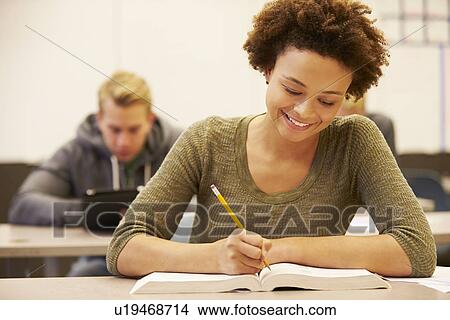 Picture - Female High School Student Studying At Desk In Classroom. Fotosearch