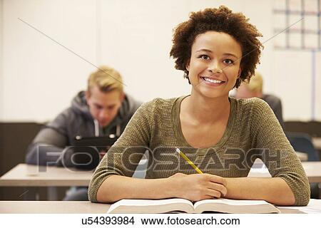 Picture - Female High School Student Studying At Desk In Classroom. Fotosearch